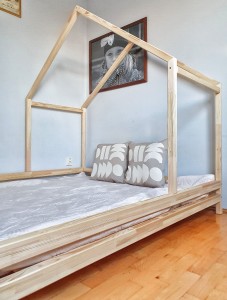 Nowoczesne łóżko domek z naturalnego drewna w pokoju starszego dziecka