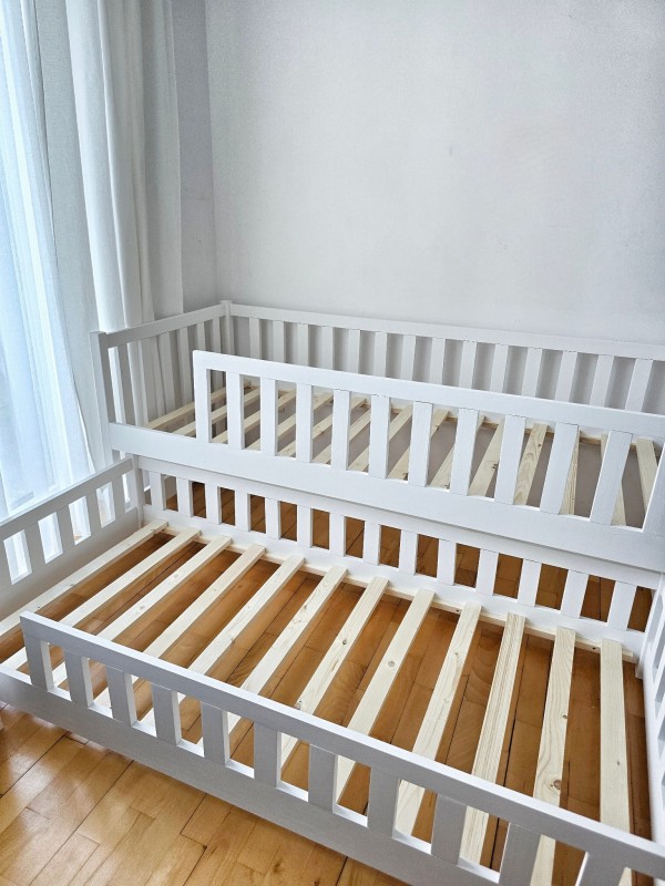 Białe łóżko piętrowe z wysuniętą dolną szufladą do spania dla dwójki dzieci