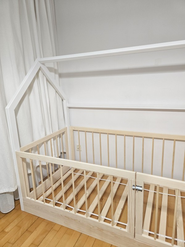 Wysokie okrągłe szczebelki tworzące bezpieczny kojec w łóżku Montessori