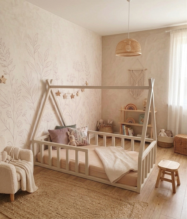 Drewniane łóżko tipi Montessori w odcieniu kaszmiru z barierkami w jasnym pokoju dziecięcym w stylu boho